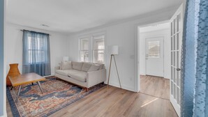 A modern living room with a sofa, a coffee table, and a patterned rug. - 2 BR Ocean Block Home (Seaside Park)