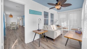 A modern living room with a white sofa, a wooden coffee table, and a ceiling fan. - 2 BR Ocean Block Home (Seaside Park)