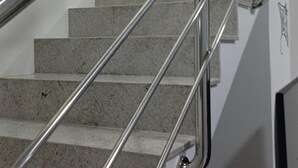 Eine Treppe mit Metallgeländern und Fliesenboden.