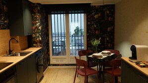 A compact kitchen with a dining area, a window with a view of the outside, and a small balcony. - Serendipity (Zaragoza)