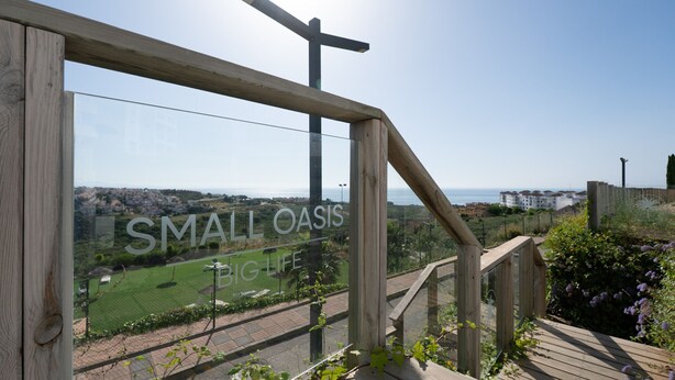 A wooden staircase leading to a viewing platform with a sign reading "SMALL OASIS BIG LIFE". - Small Oasis Manilva - Cozy Apartment (Manilva)