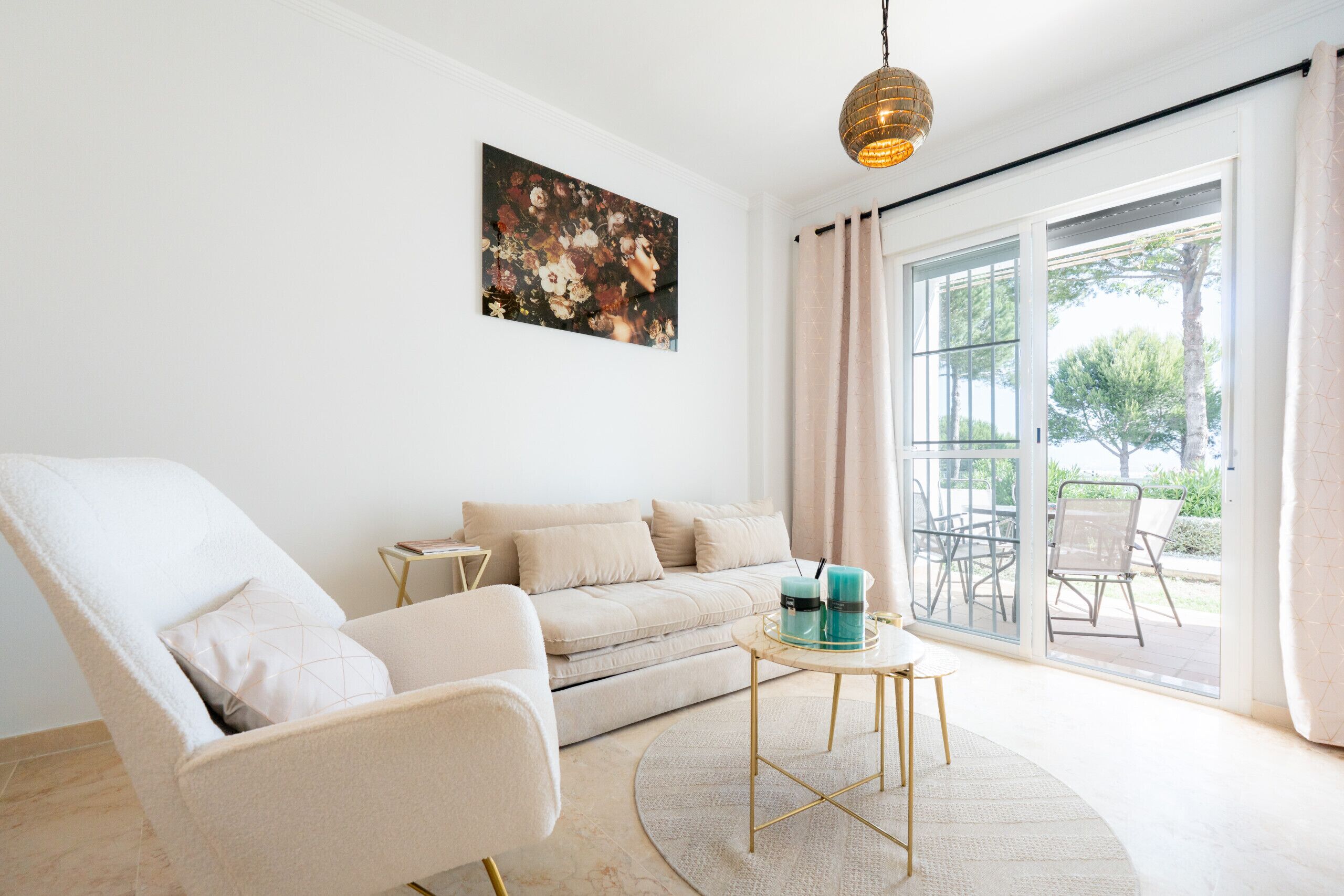 A modern living room with a sofa, armchair, and a round coffee table.