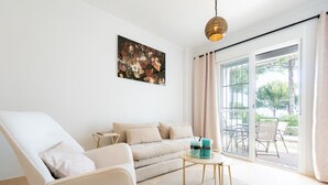A modern living room with a sofa, armchair, and a round coffee table. - Small Oasis Manilva - Cozy Apartment (Manilva)