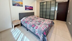 A bedroom with a bed, a wardrobe, and two paintings on the wall. - Alimos Cozy Apartment (Alimos)