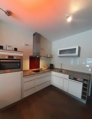 Eine moderne Küche mit integrierten Geräten, einer Mikrowelle und einem Spülbecken.