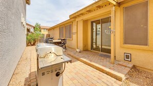 A patio with a grill, a table, and chairs, and a covered area with a sliding door. - Family Home w/ Community Perks - 8 Mi to Chandler! (Gilbert)