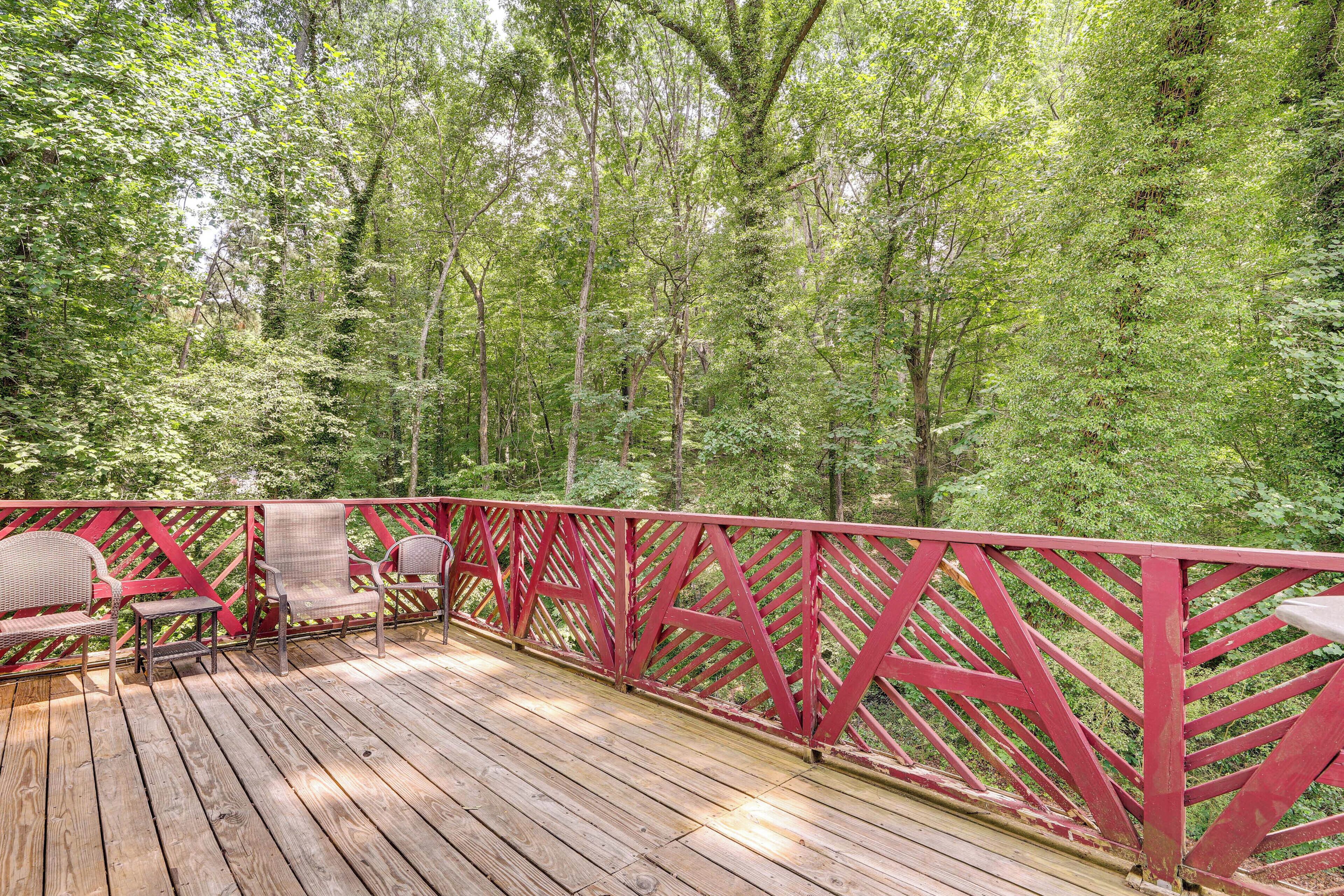 Une terrasse en bois avec des rampes rouges et des chaises en osier.