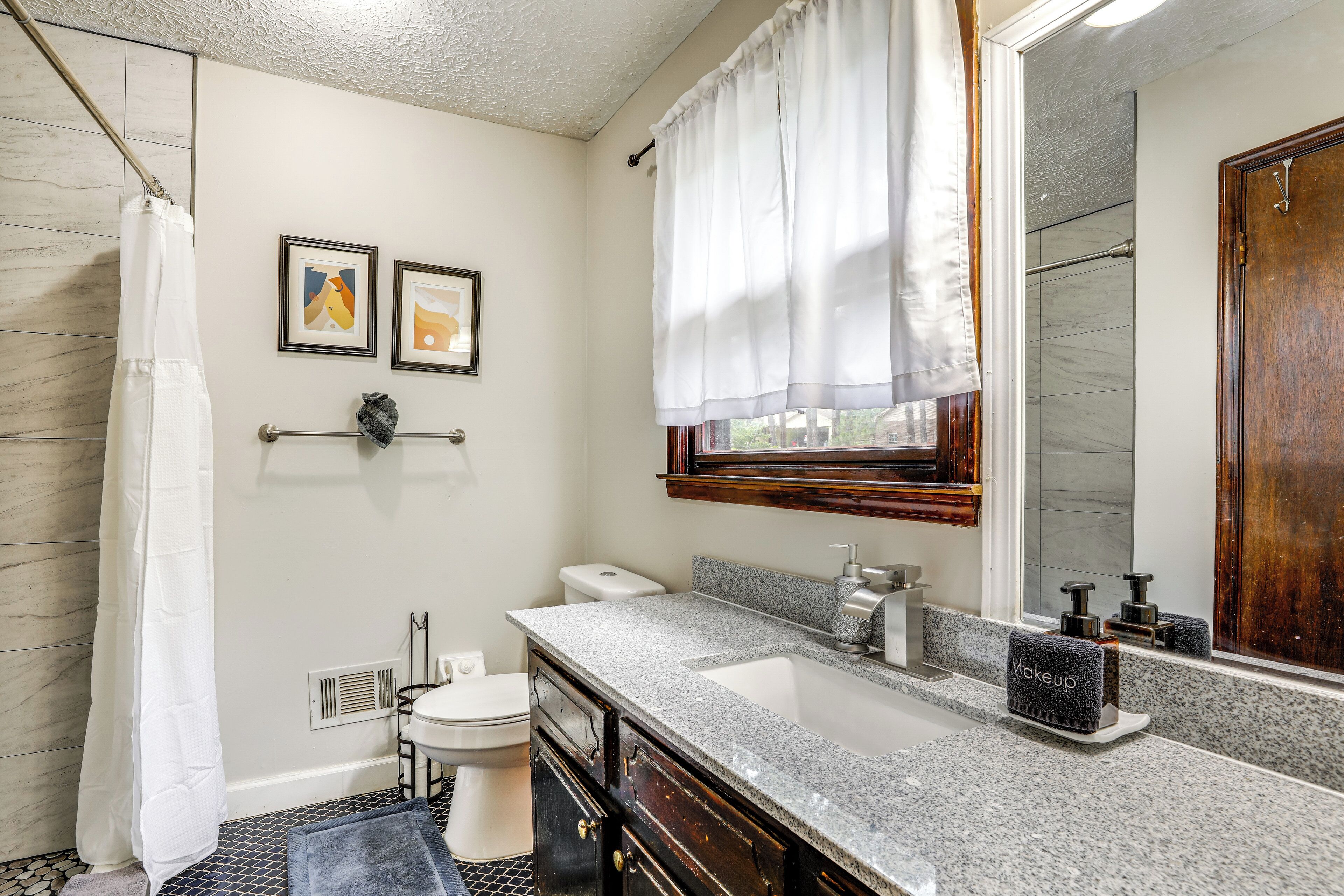 Een badkamer met douche, toilet, wastafel en badkamermeubel.