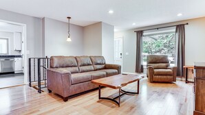 A modern living room with a leather sofa, a wooden coffee table, and a leather armchair. - 8 Mi to Central Minneapolis: Modern Home w/ Yard (Richfield)