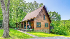 A wooden cabin with a porch, surrounded by lush greenery and trees. - Blue Ridge Mtns Retreat w/ Views, 1 Mi to Parkway! (Hillsville)