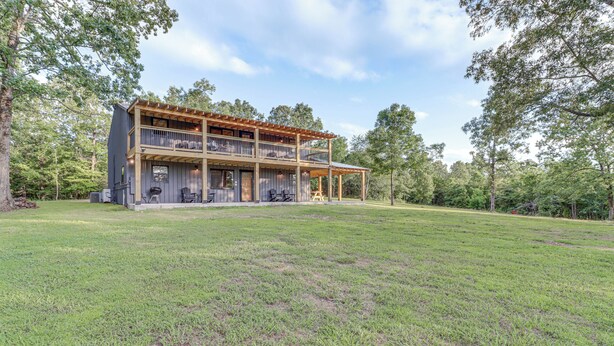 A two-story house with a covered porch and a large lawn.