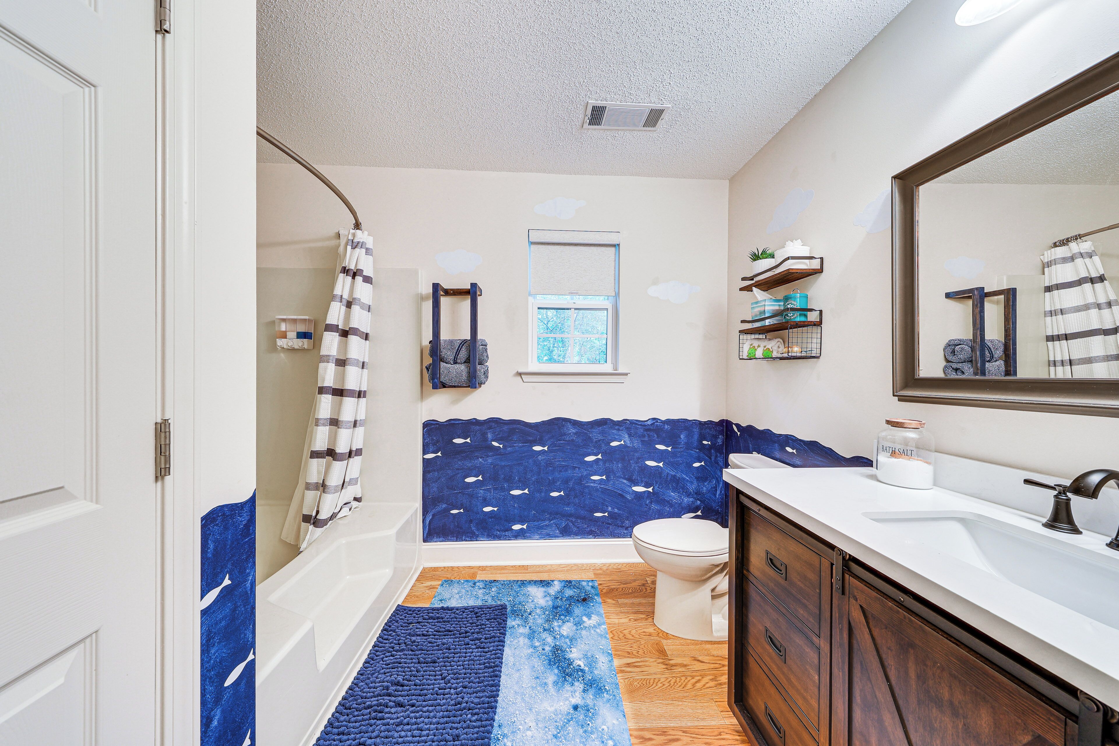 A bathroom with a bathtub, a toilet, a sink, and a shower area.