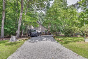 A gravel driveway leading to a house surrounded by trees.