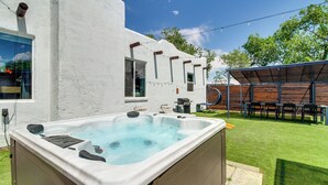 A hot tub in a backyard with a wooden deck and a covered patio area. - Newly Renovated Albuquerque Retreat w/ Pool Table (Albuquerque)