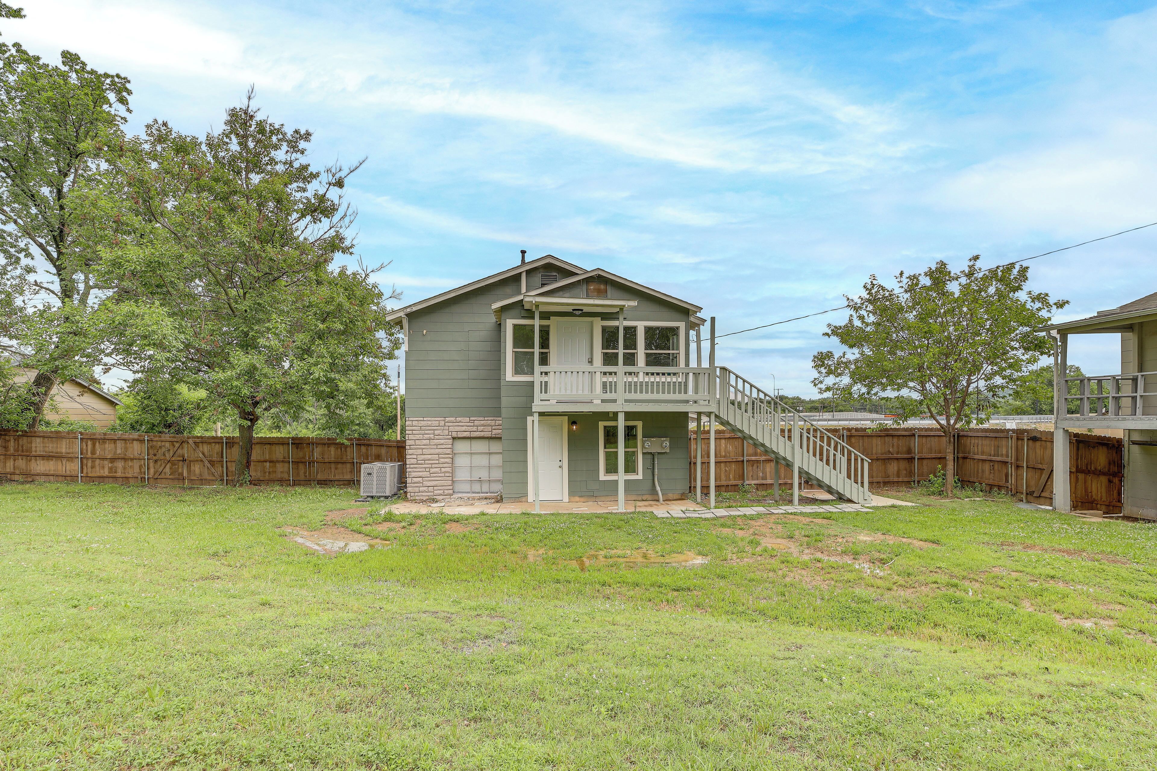 A two-story house with a front porch and a small staircase leading to the second floor.
