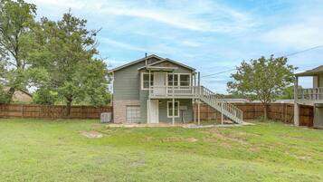 A two-story house with a front porch and a small staircase leading to the second floor.
