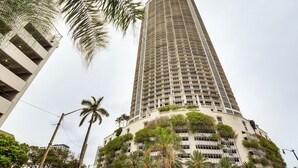 Un grand hôtel cylindrique, doté de nombreux balcons et d’une végétation luxuriante.