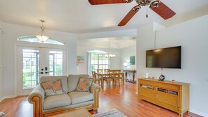 Amplia sala de estar con sofá, mesa de comedor y televisor.