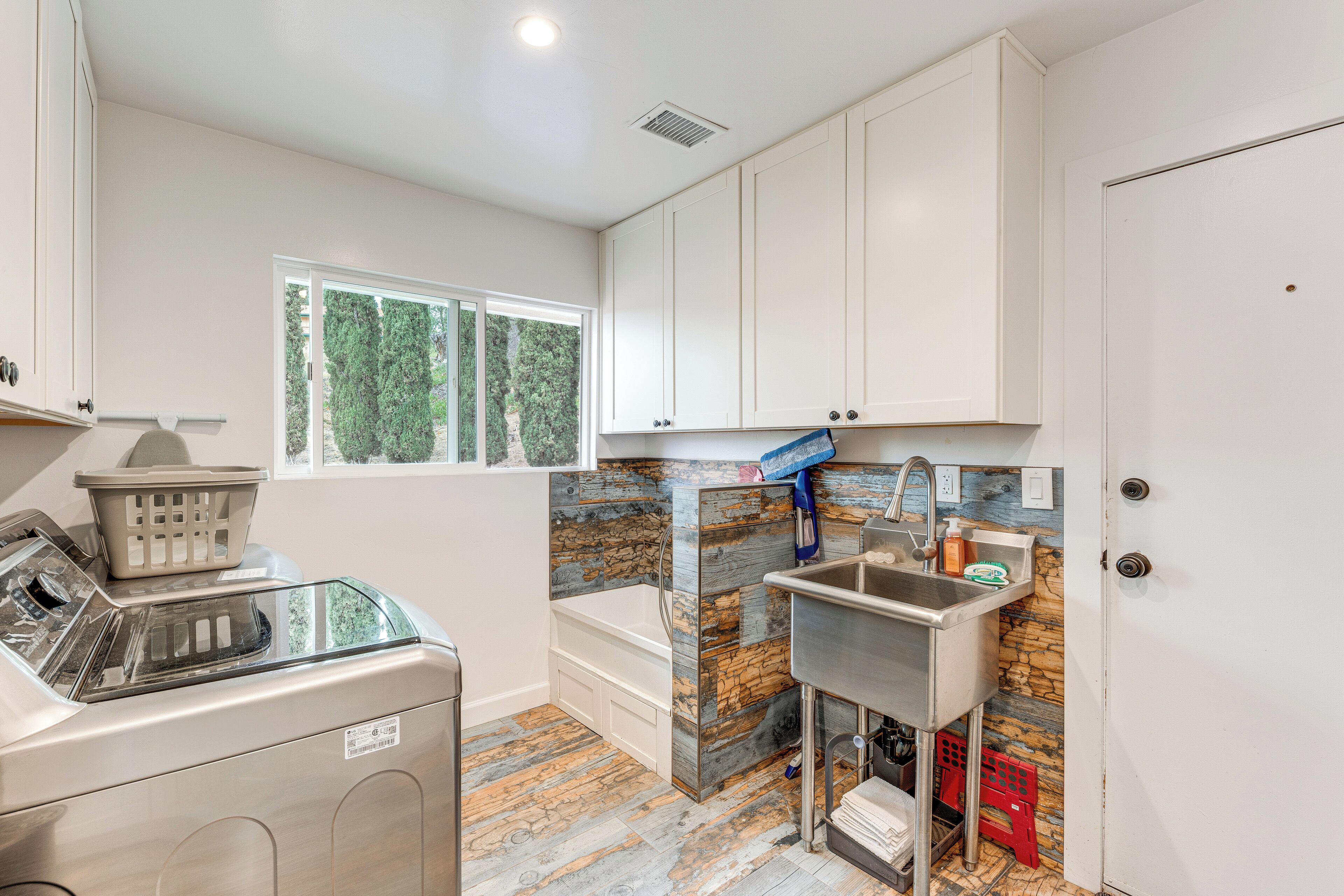 A laundry area with a washing machine, a dryer, and a utility sink.