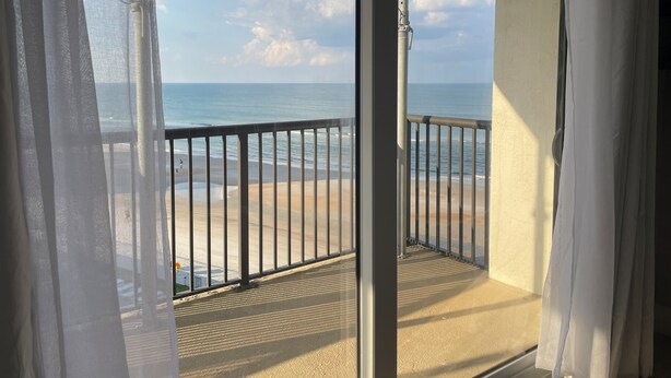 Un balcon avec vue sur la plage et l’océan.