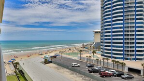 A beachfront hotel with a pool, beach access, and a parking area.