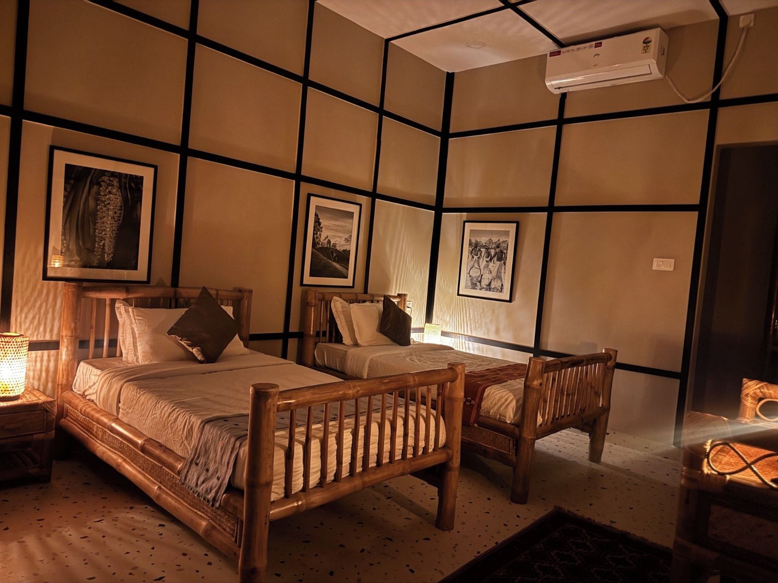 A room with a bed, two chairs, a bedside table, and wall-mounted artwork.