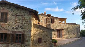 A stone building with multiple windows and a balcony. - Villa Este con Piscina (Civitella Paganico)