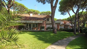 A house with a tiled roof, a stone pathway, and a well-maintained lawn. - Villa Gio-d con Grande Giardino (Grosseto)