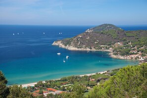 A coastal town with a prominent hill, clear blue sea, and several boats. - Villa Stefania Isola d Elba (Portoferraio)