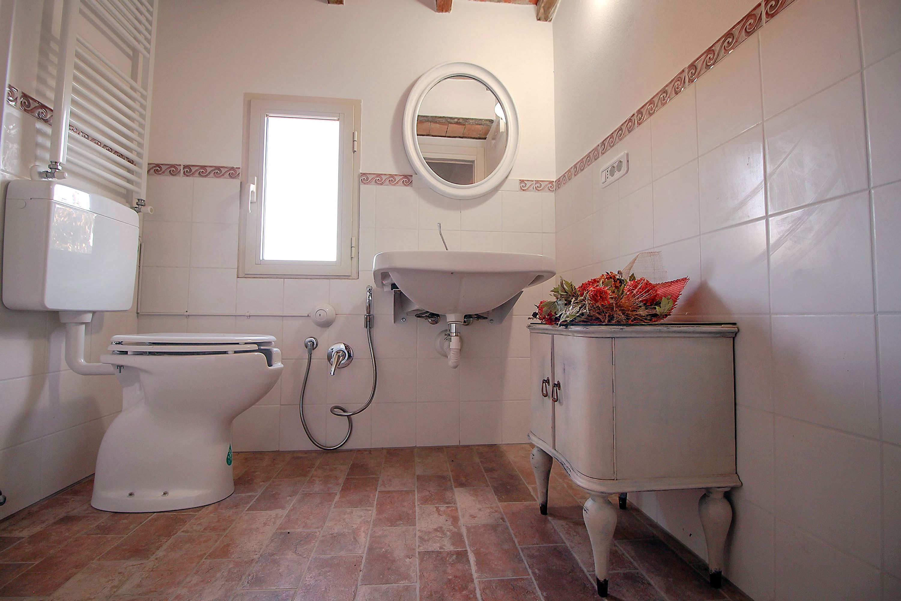Un bagno con il water, un lavandino e uno specchio.