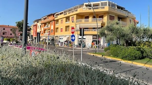 Un immeuble à plusieurs étages doté de balcons, d’un panneau de signalisation indiquant un arrêt et d’un panneau de signalisation bleu indiquant la direction.