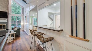 Eine moderne Küche mit Bar, Holzboden und Blick auf den Garten.