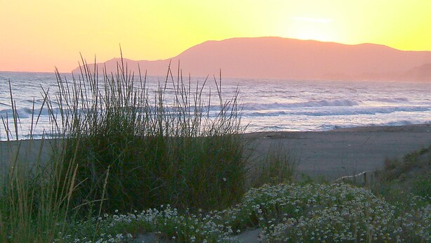 A coastal landscape with a beach, waves, and a mountain in the background. - Appartamento Malibu Vicino Alla Spiaggia (Grosseto)