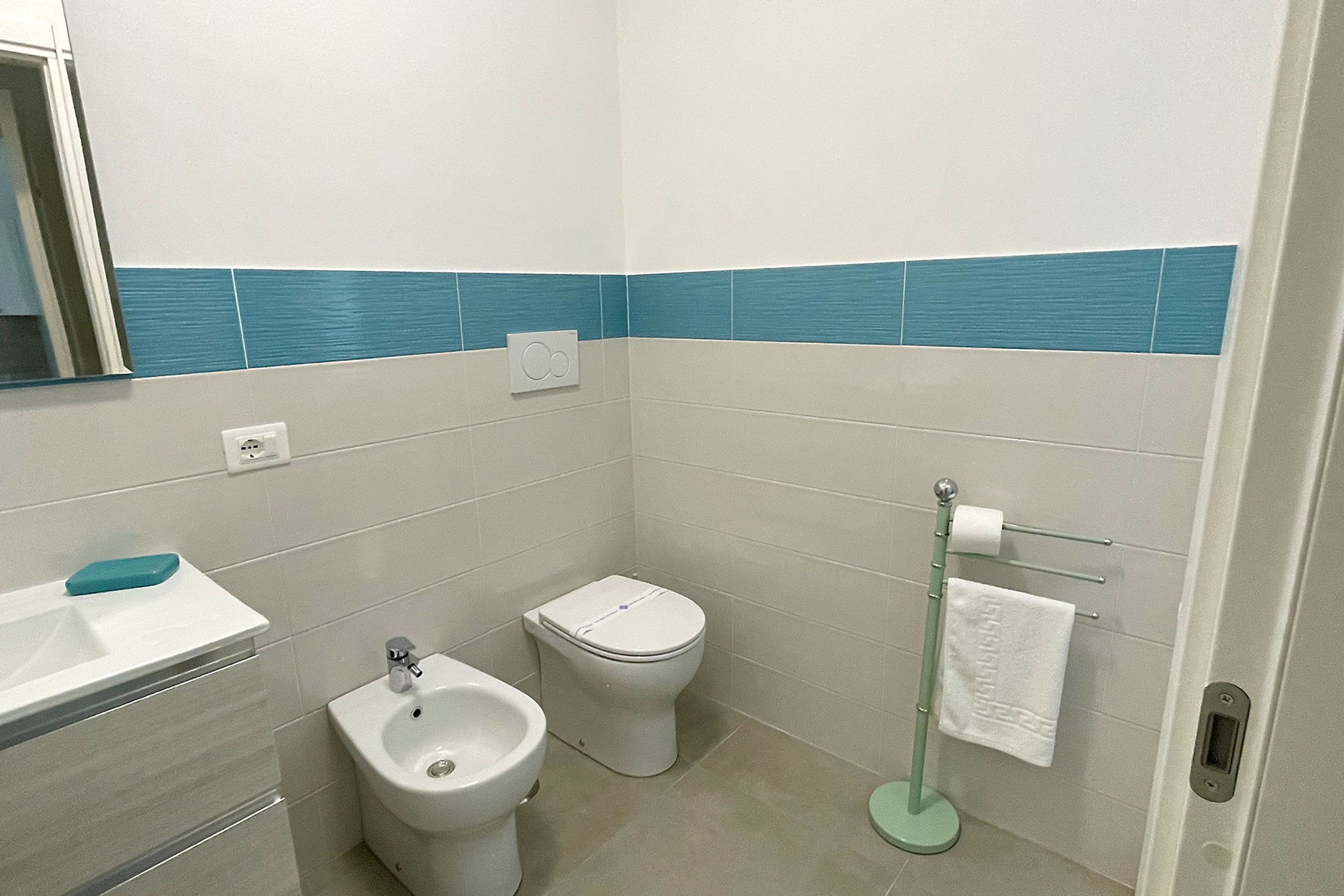 Ein Badezimmer mit Bidet, Toilette, Waschbecken und Handtuchhalter.