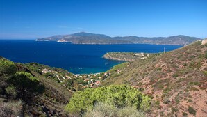 Un paysage côtier offrant une vue dégagée sur la mer et les montagnes lointaines.