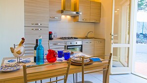 Une cuisine moderne avec des meubles en bois, une cuisinière à gaz et une table à manger dressée avec des assiettes et des verres.