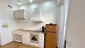 Una cocina compacta con horno empotrado, refrigerador y microondas.