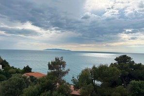 A coastal view with a clear sky, calm sea, and dense greenery. - Appartamento Blue Sea con Vista Mare (Orbetello)