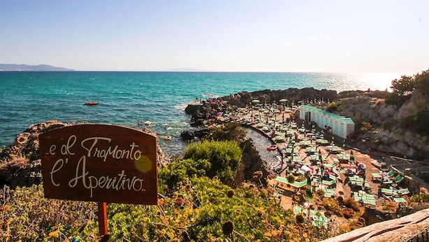 Una zona costanera amb un senyal que diu 'Tramonto L'Aperitivo'.