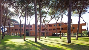 A building with multiple floors and a courtyard surrounded by trees.