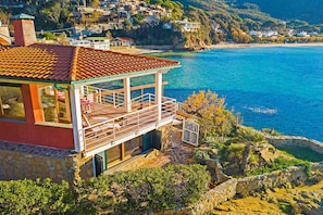 A coastal property with a balcony overlooking the sea, stone walls, and a view of nearby houses. - The Boat Isola d Elba (Portoferraio)