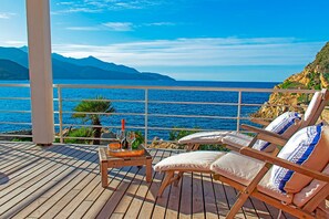 A wooden deck with lounge chairs and a table with a bottle and glasses. - The Boat Isola d Elba (Portoferraio)