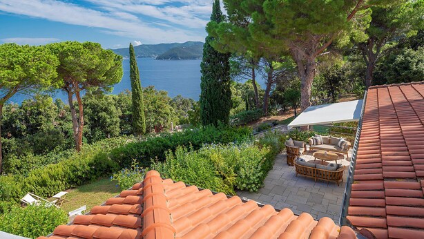A terrace with a red-tiled roof, outdoor furniture, and a view of the sea. - Villa Ondina - Isola d Elba (Marciana Marina)