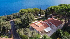 A coastal property with a red-tiled roof, surrounded by lush greenery and overlooking a clear blue sea. - Villa Ondina - Isola d Elba (Marciana Marina)