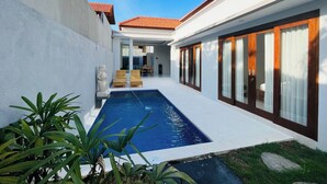 A modern house with a swimming pool, large windows, and a patio area. - Milmai Villa (Bali)