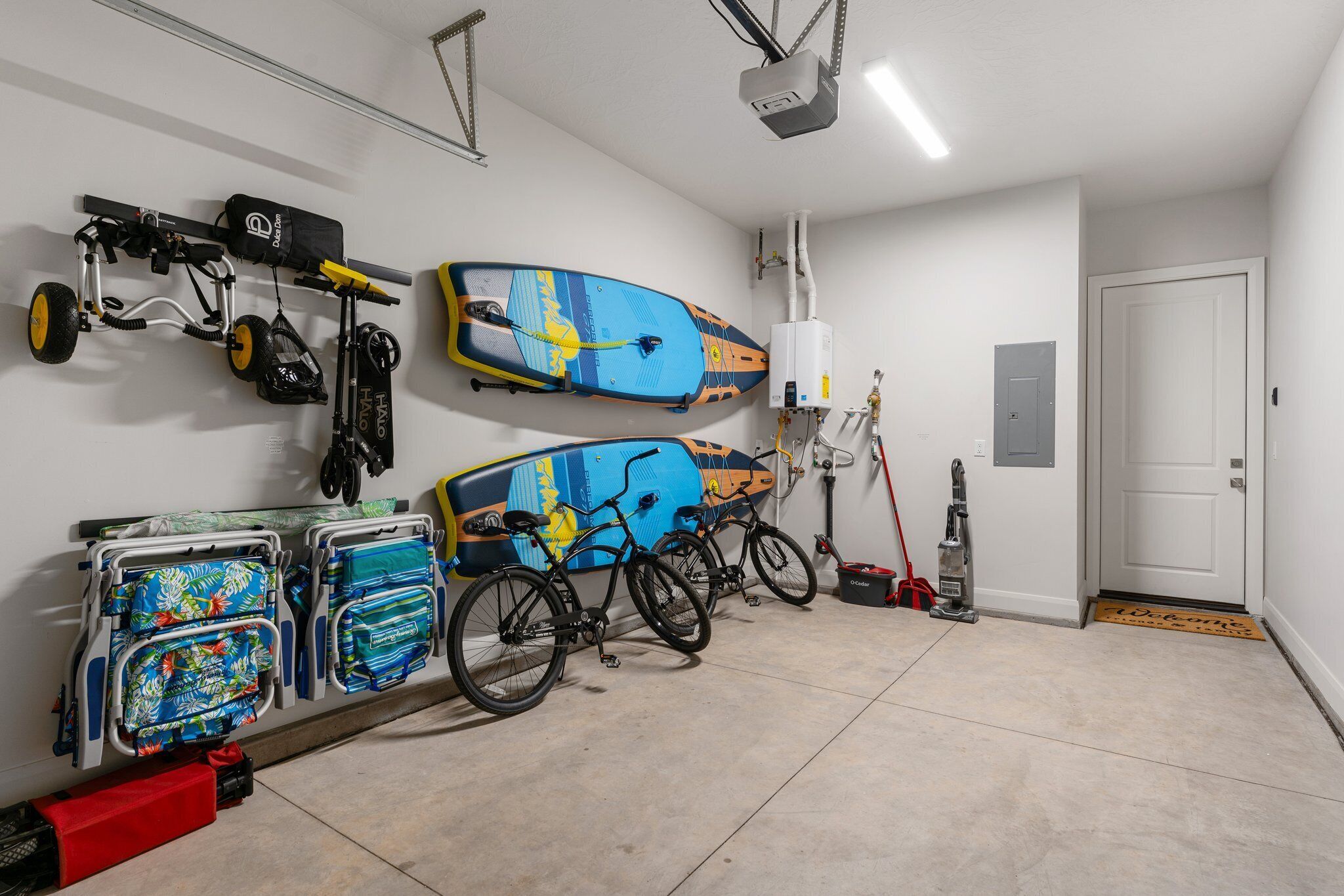 Eine Garage mit zwei Fahrrädern, einem Surfbrett und einem Rollstuhl.