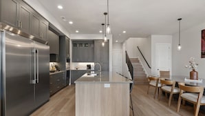 A modern kitchen with a central island, stainless steel appliances, and wooden flooring. - Canyon Country Oasis: Desert Color Lagoon + Beaches (St. George)