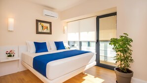 A modern bedroom with a large bed, a potted plant, and a balcony with a view. - Orbi Panorama Sea Resort (Batumi)