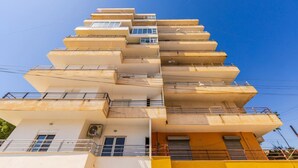 Un edificio de varios pisos con balcones y un cielo despejado.