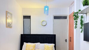 Ein modernes Schlafzimmer mit einem Bett, einem Nachttisch und einem an der Wand befestigten Fernseher.